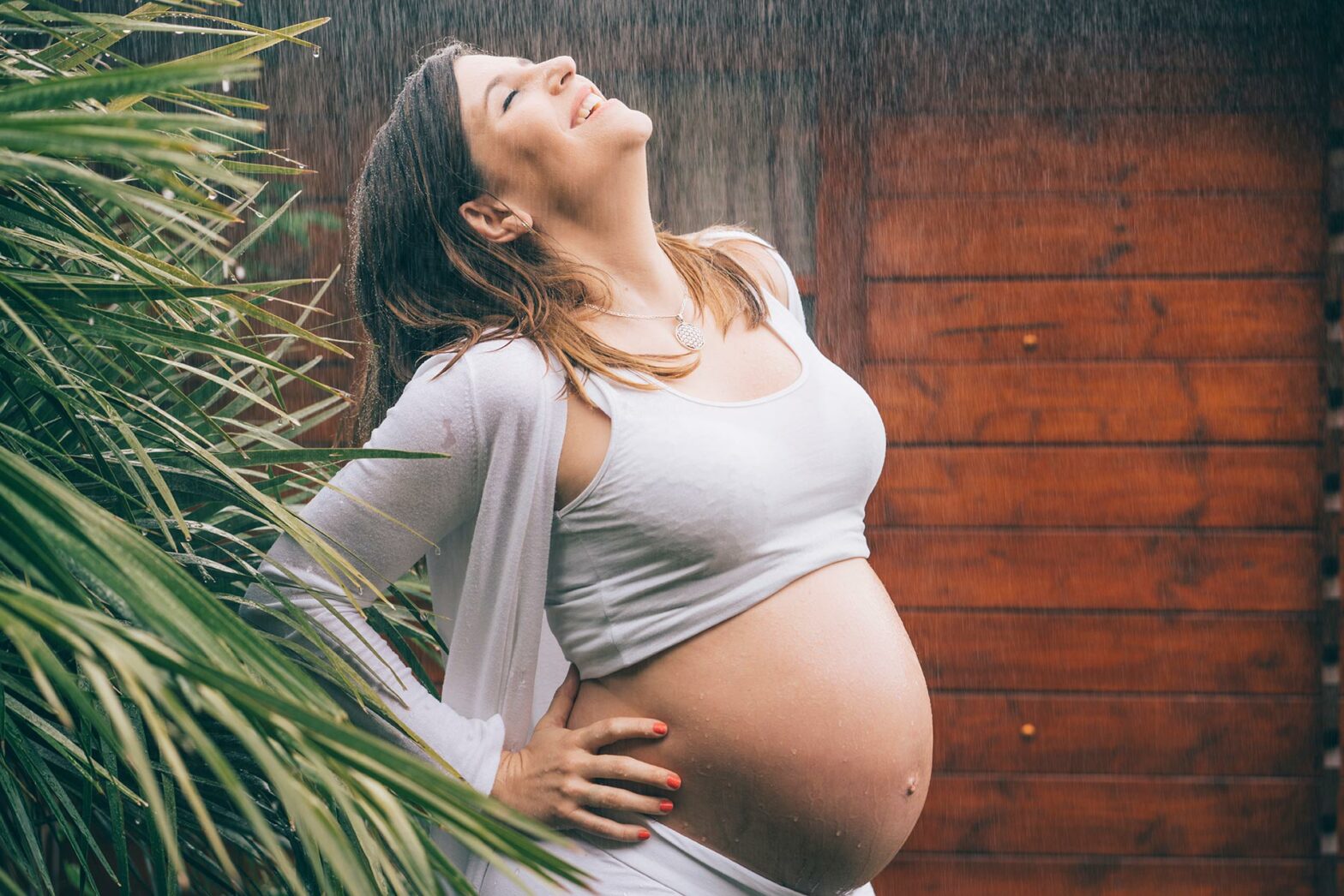 Femme enceinte tenant son ventre, représentant l'accompagnement des femmes en santé et bien-être.